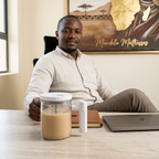 White self-stirring glass mug on a home office desk